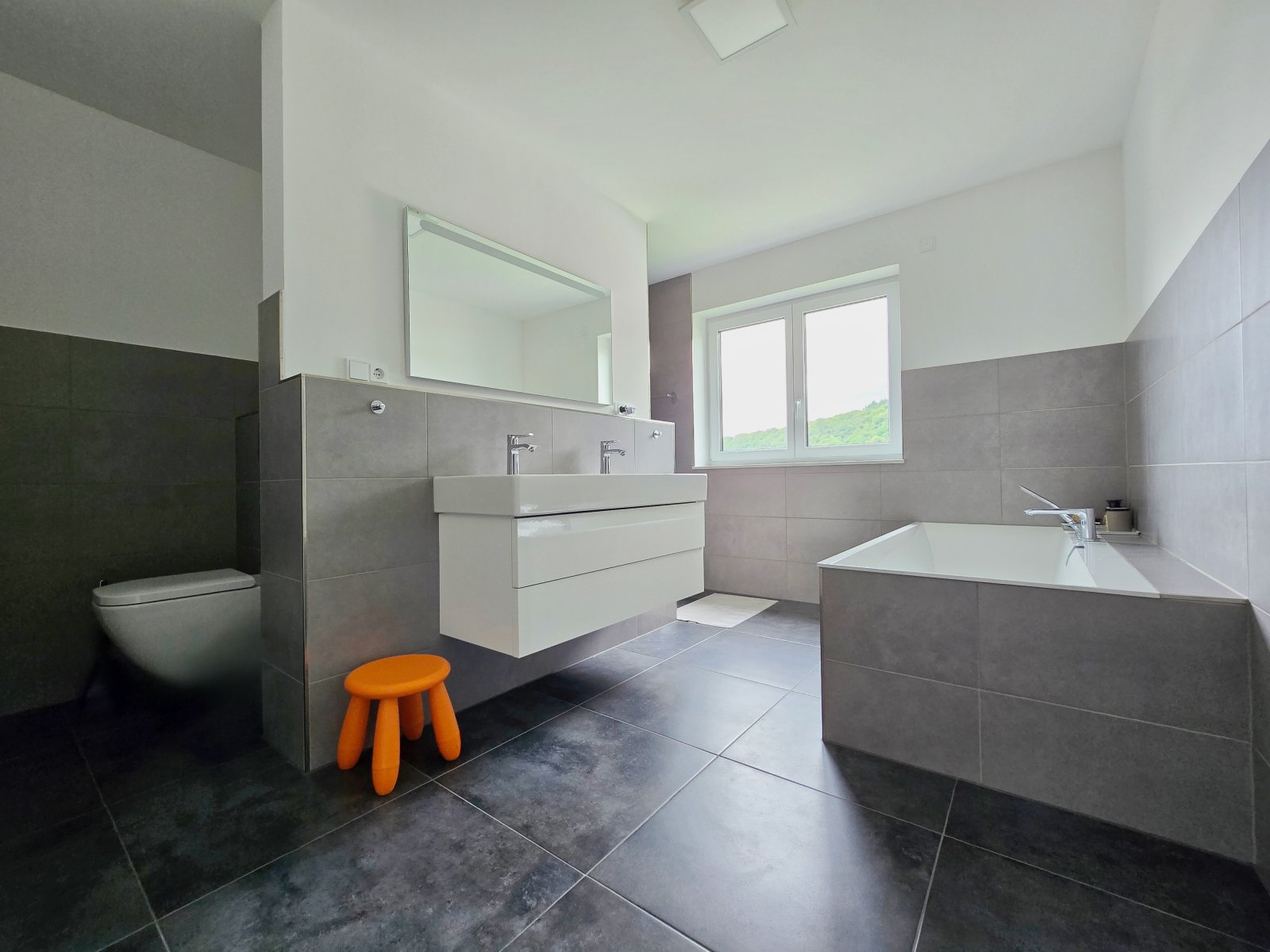 Familienbad mit Wanne, bodengleicher Regendusche und WC